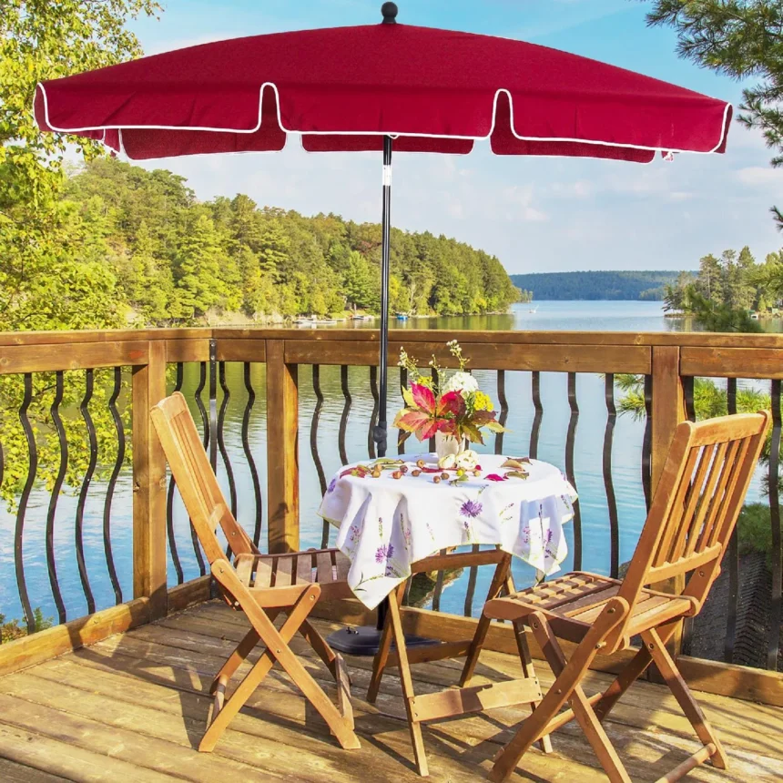 Ombrellone rosso con due sedie di legno con vista lago