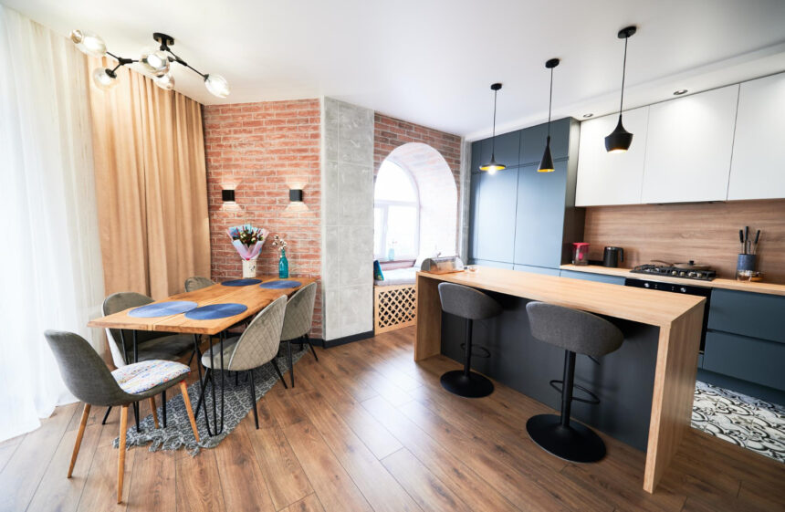 Cucina con interni moderni, tavoli con sedie e lampade a soffitto